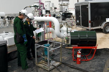 两个贝克休斯工程师在一个炼新利app油厂的照片。